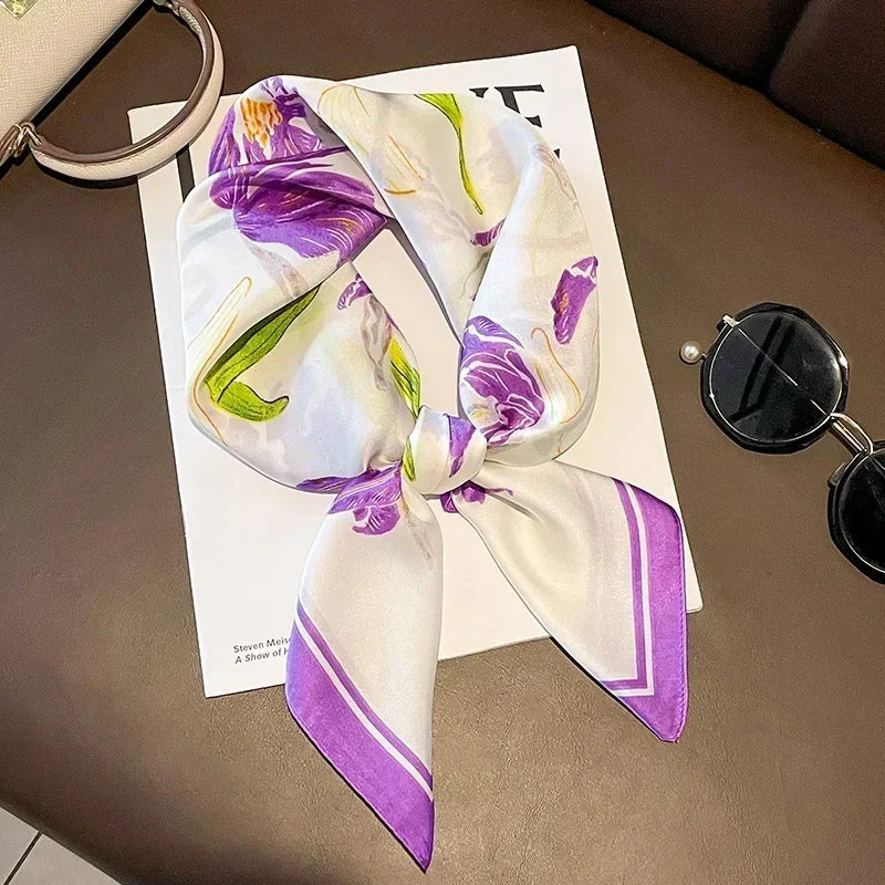 Foulard en satin vert clair, violet et blanc imprimé floral noué en bandeau.
