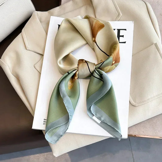 Zoom sur les motifs floraux du foulard au fini satiné brillant.