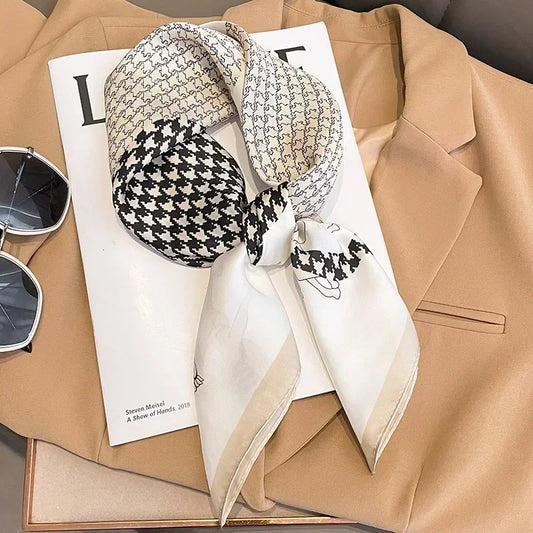 Foulard noir et blanc motif pied-de-poule porté autour du cou avec un blazer.