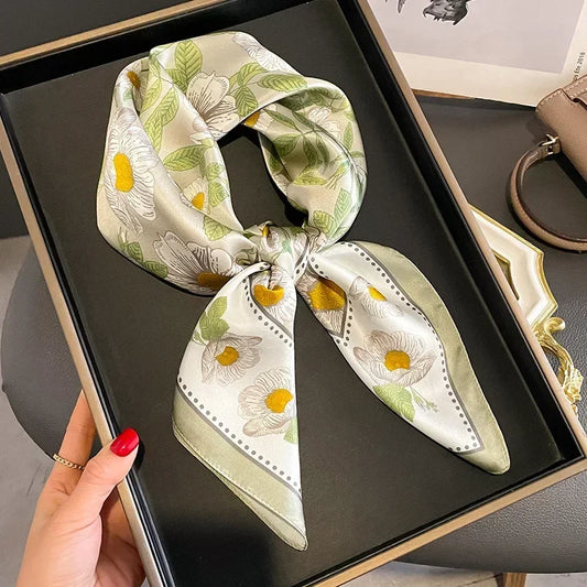 Foulard en satin vert clair et blanc imprimé floral noué en bandeau.
