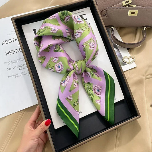 Foulard carré rose clair et vert, avec motif floral au centre.