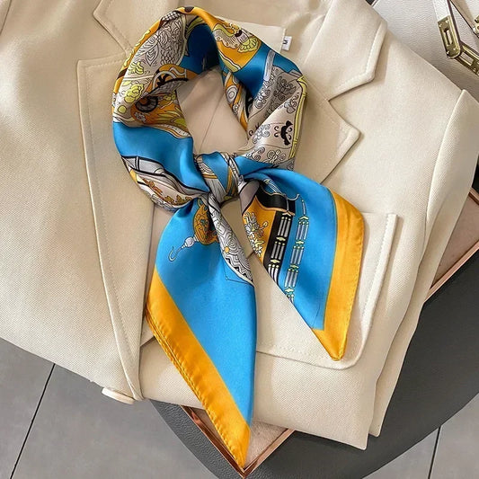 Foulard vintage bleu clair, jaune aux motifs luxueux, parfait pour être porté en bandeau avec une tenue estivale chic.