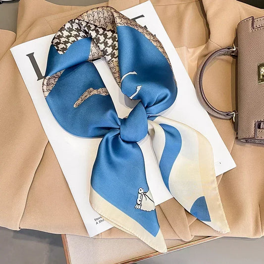 Foulard carré bleu, blanc et gris à plat sur fond neutre.