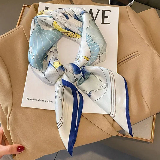 Foulard blanc et bleu porté parfait pour être noué au cou sur une robe d’été claire.