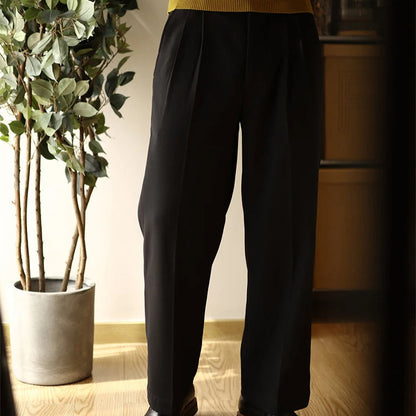 Vue du pantalon SLOANE noir, avec sa coupe droite ample et ses plis marqués, pour une silhouette élégante et structurée. Le tissu respirant assure un confort de longue durée.
